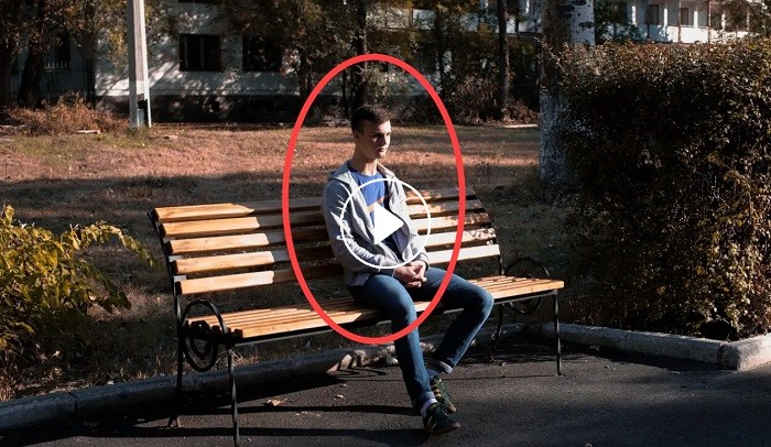 The guy is sitting quietly on the bench. Now watch the video at 0:11